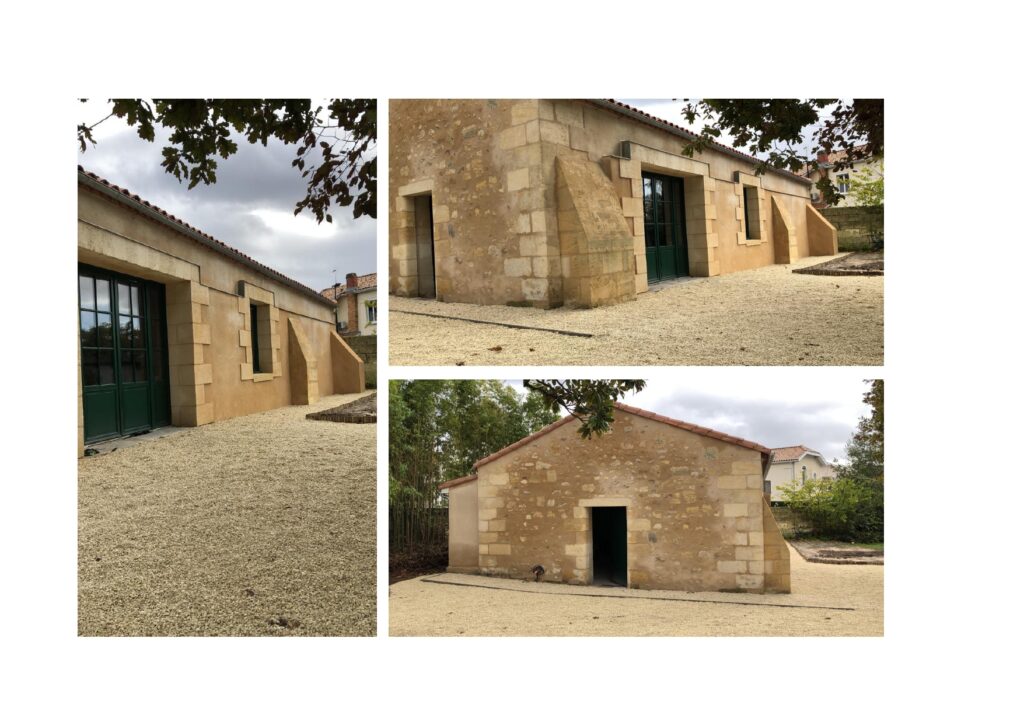 Rénovation de façade en pierre et crépi ocre traditionnel Maison en pierre rénovée avec crépi ocre, menuiseries vertes et contreforts sur une cour de gravier clair.
